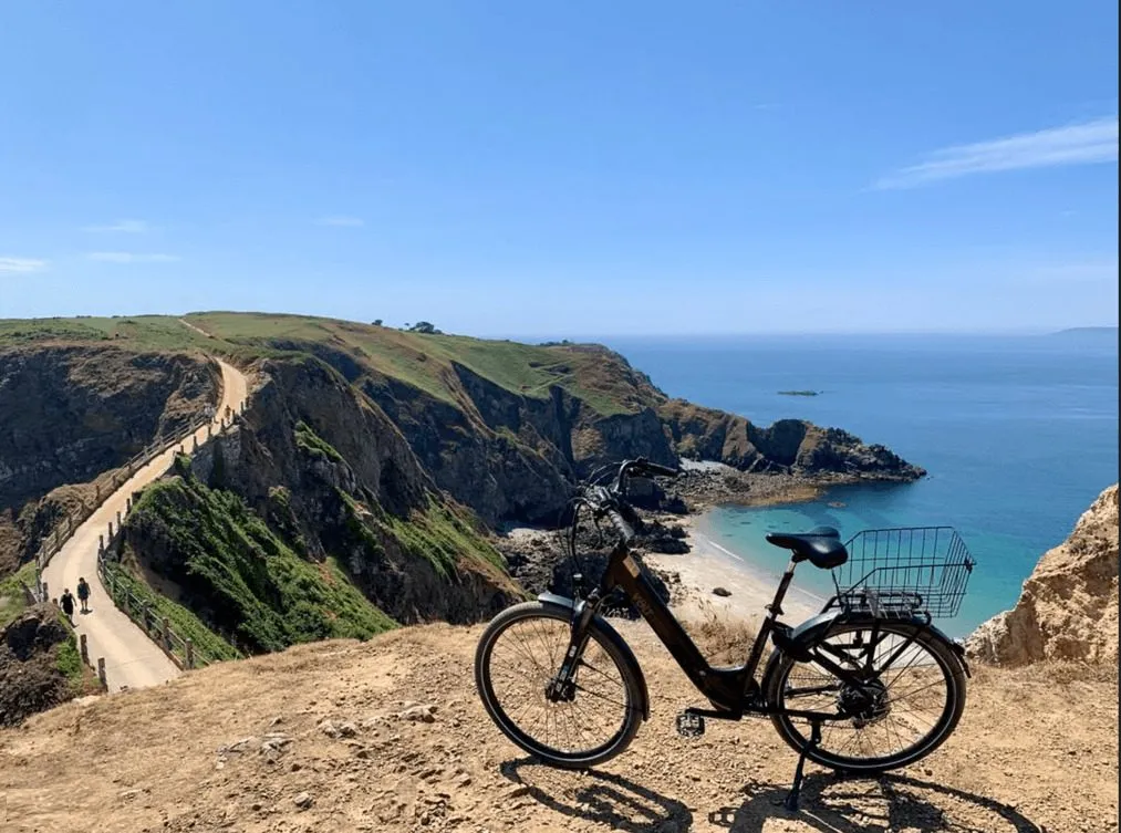 Cycling above the turquoise bays near La Coupée on Sark, Channel Islands