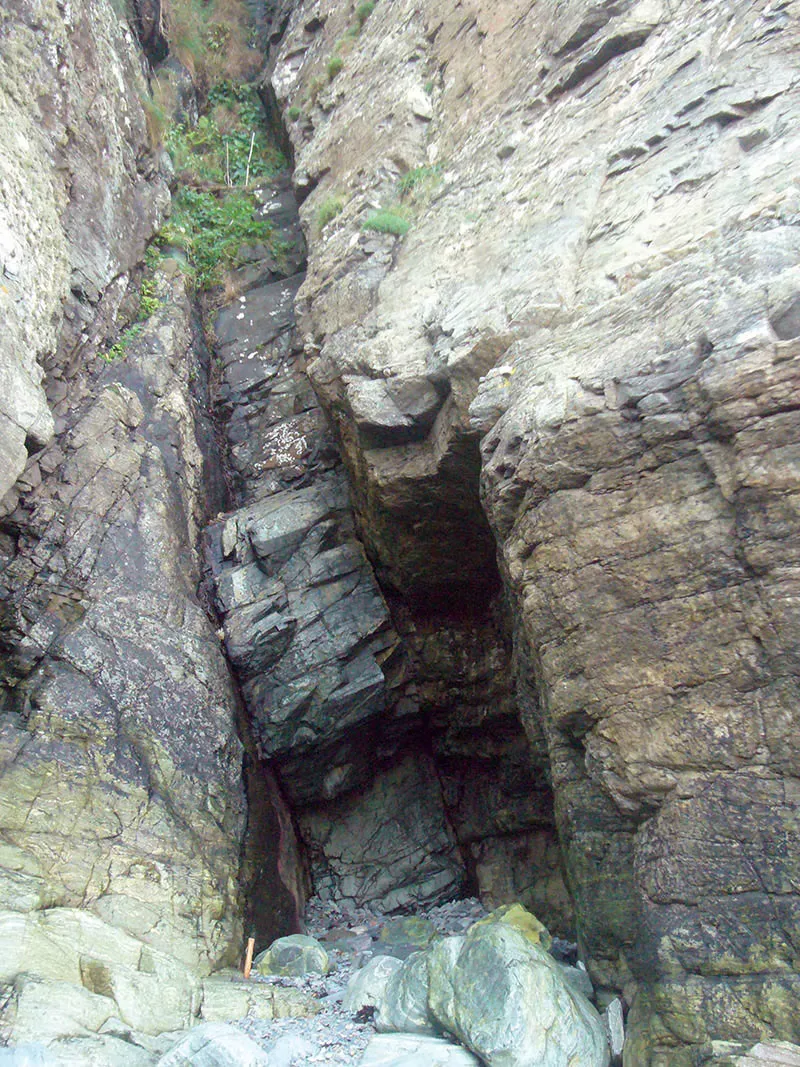 A narrow dark cleft running up through wet cliff rock, Sark, Channel Islands
