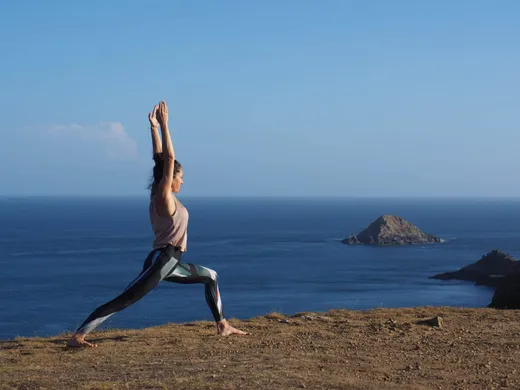 Warrior pose on the clifftop above the sea on Sark, Channel Islands