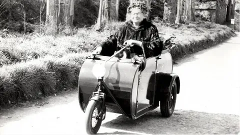 Dame Sibyl Collings riding in a motorised sidecar on a Sark lane in later life
