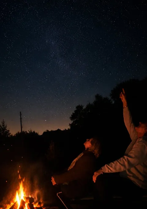 Stargazing by firelight under the night sky on Sark, Channel Islands