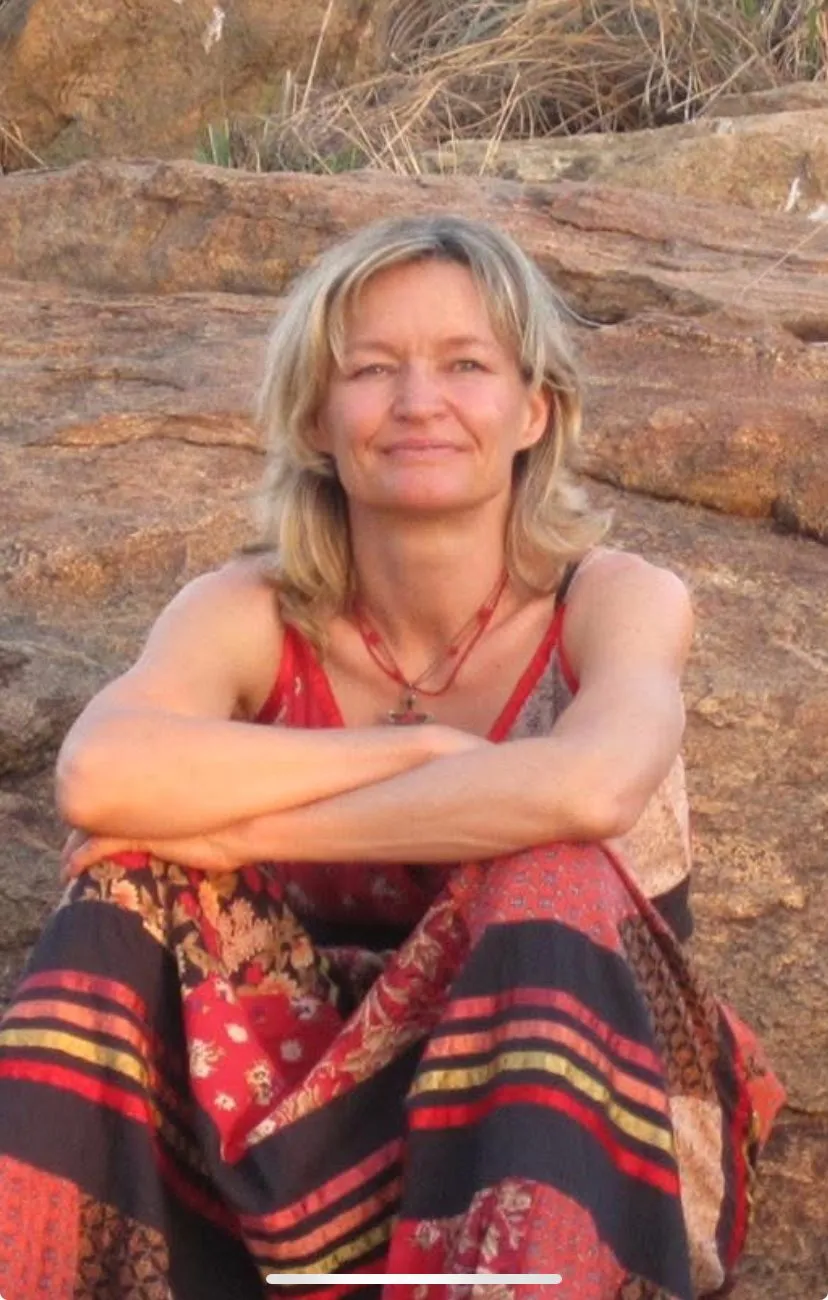 Louise, Reiki practitioner, yoga teacher and artist, on the rocks by the sea on Sark