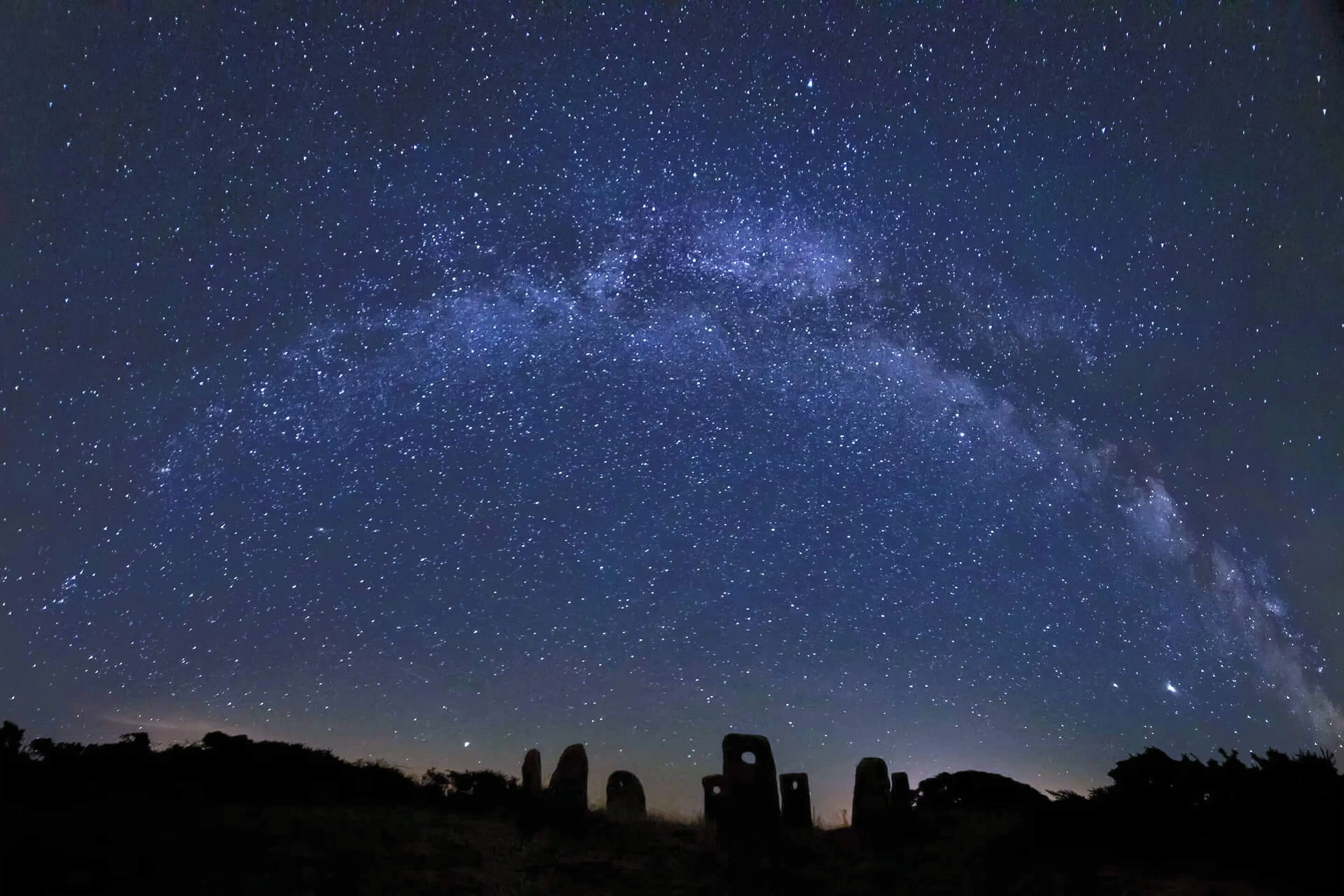 The Milky Way arching over the standing stones of Sark Henge, Sark