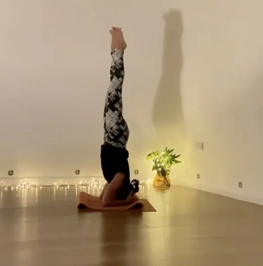 Monica of YogaMorphic practising a candlelit headstand