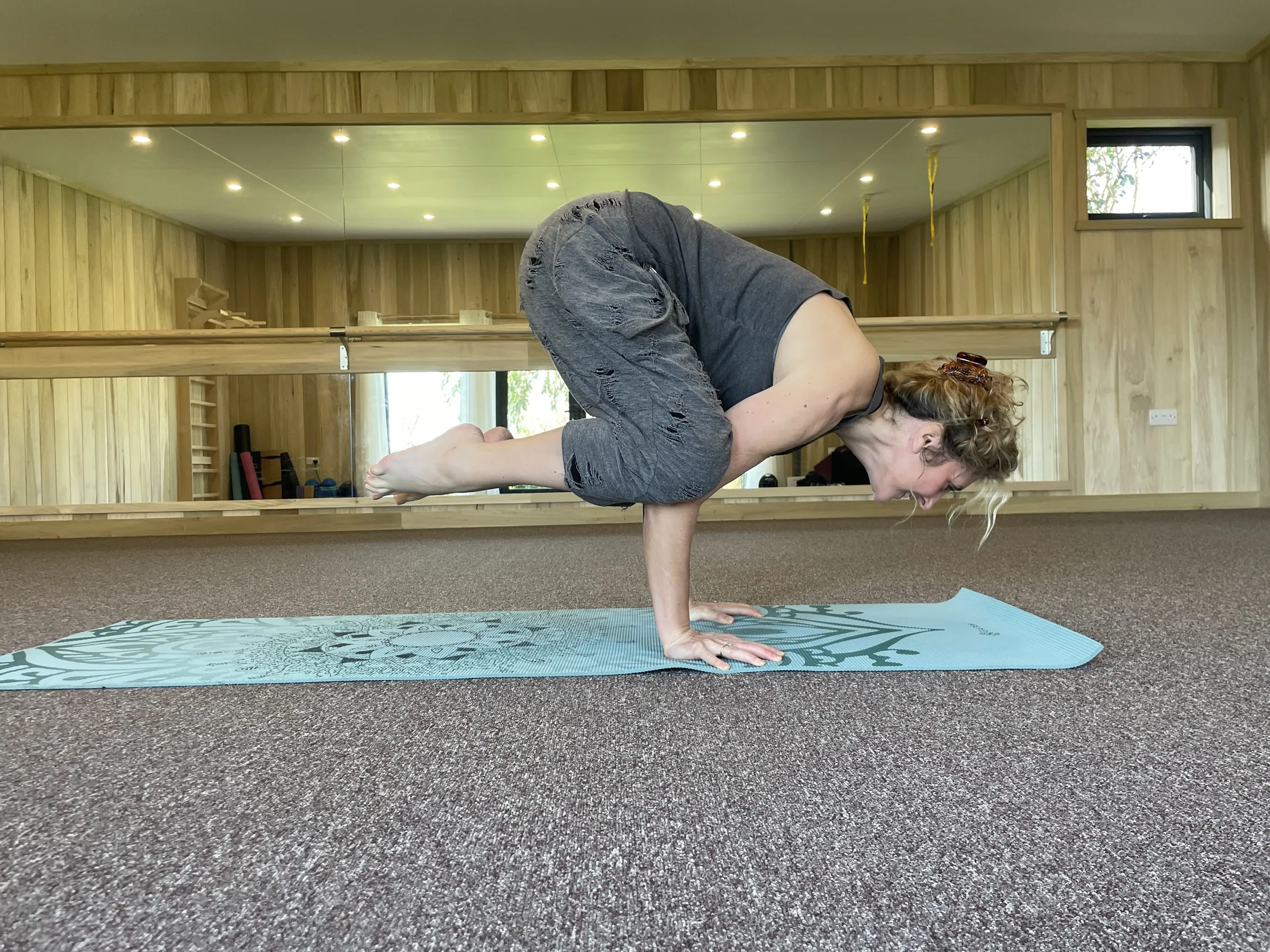 Nadia practising crow pose in the studio on Sark