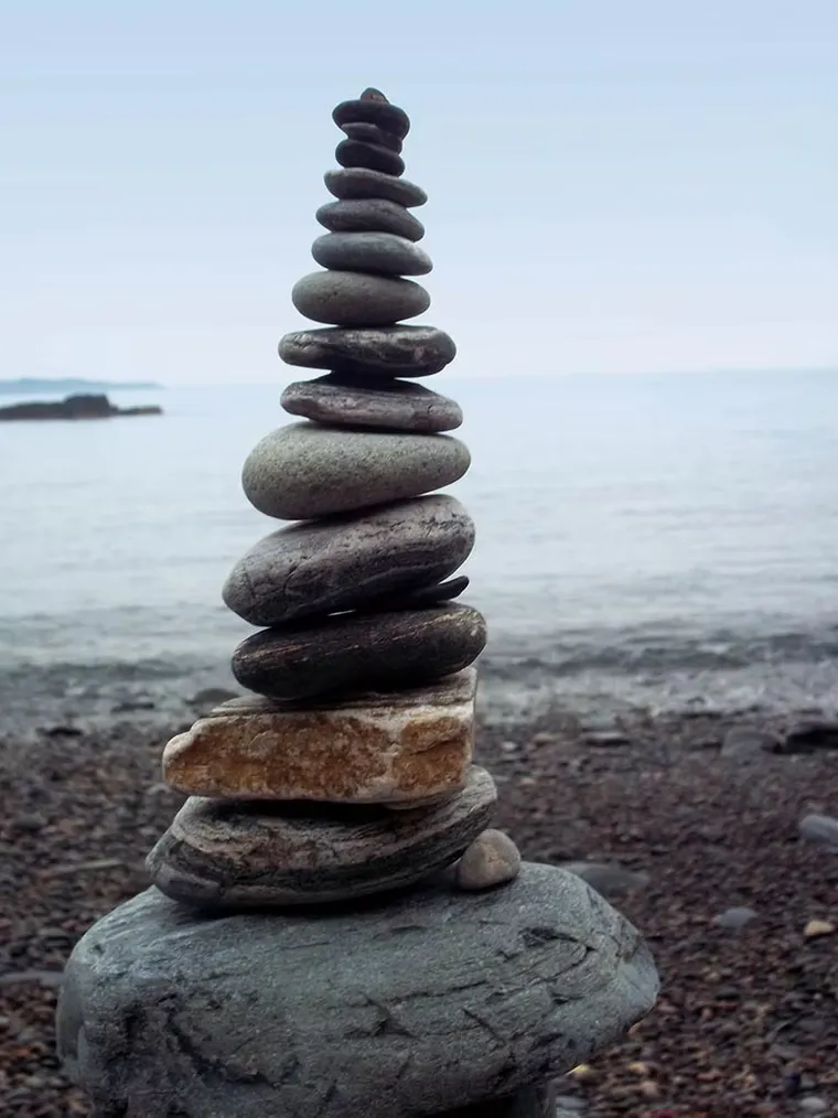 A stacked pebble cairn on a quiet shingle beach on Sark, Channel Islands