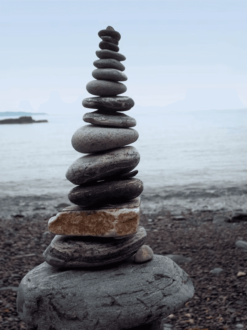 A stacked pebble cairn on a quiet shingle beach on Sark, Channel Islands