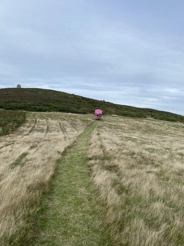 A chair on a hilltop path above the sea on Sark, Channel Islands