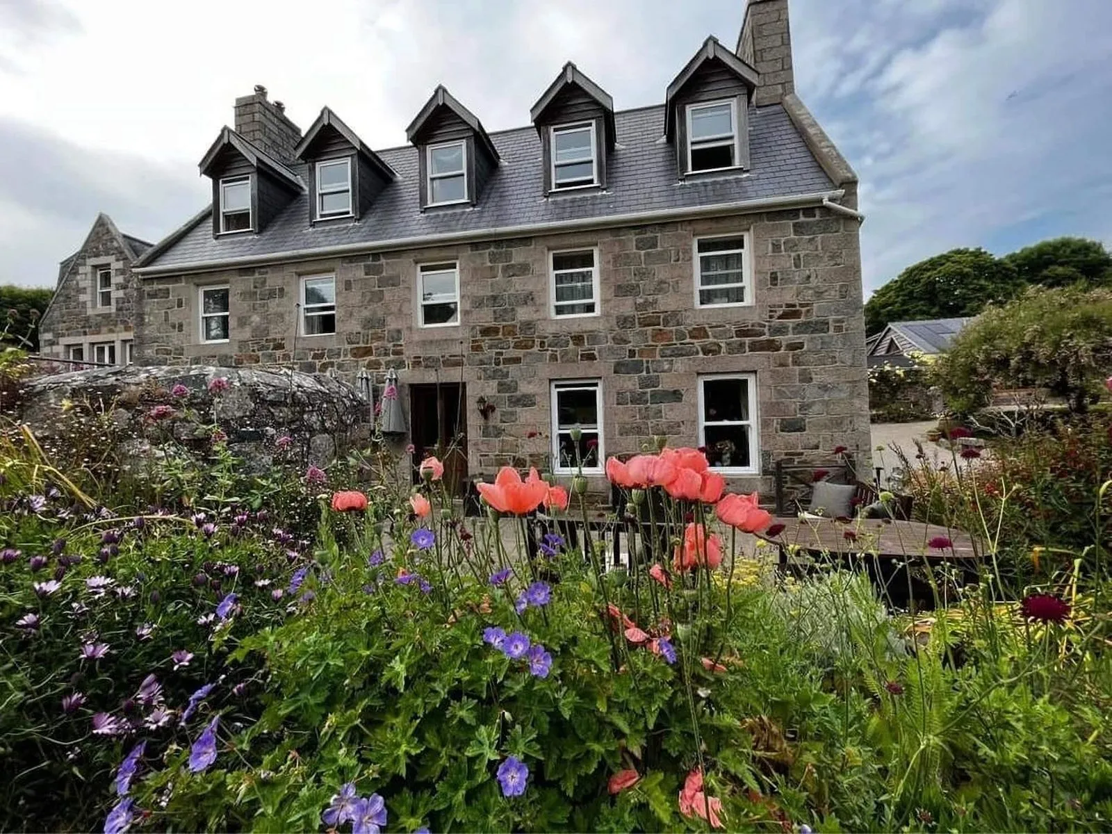 The historic farmhouse behind summer poppies on Sark, Channel Islands