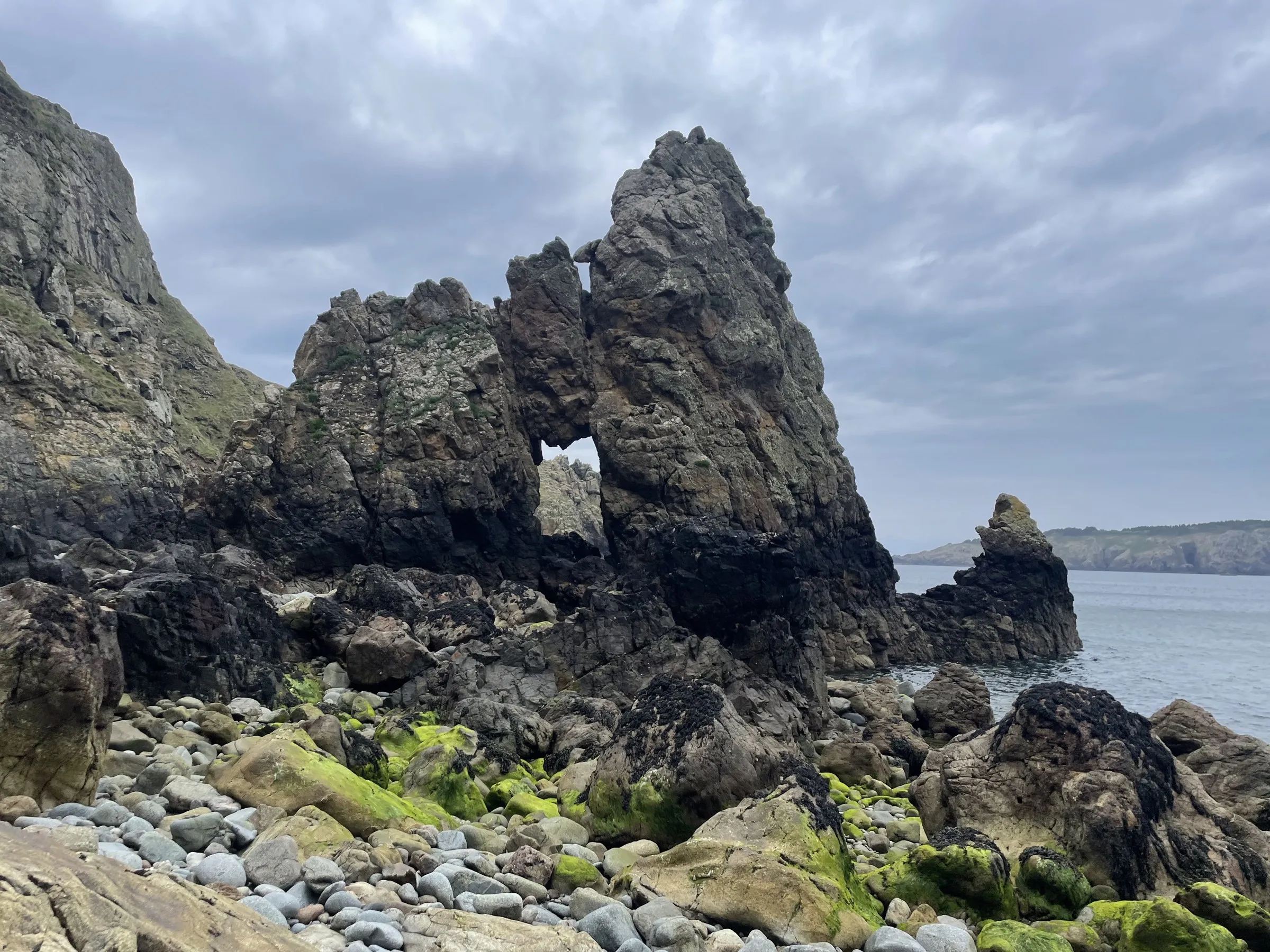 A natural rock arch on the wet coastline of Sark