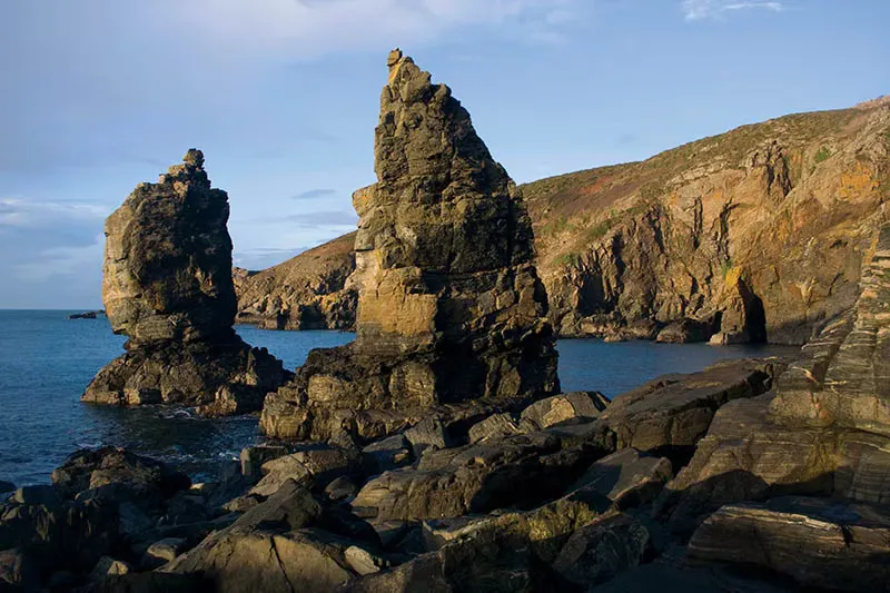 Sea stacks and dark rock in low evening light off the coast of Sark, Channel Islands