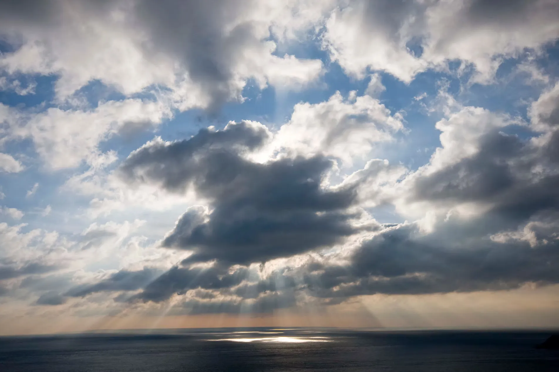 Sunbeams breaking through clouds over the sea off Sark