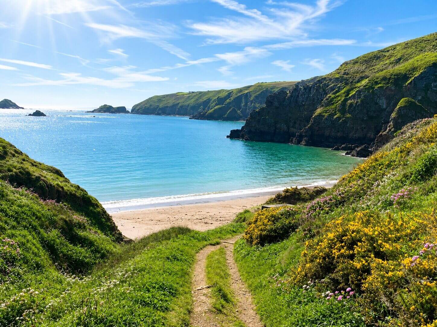 A grassy path down to a turquoise bay on Sark, Channel Islands