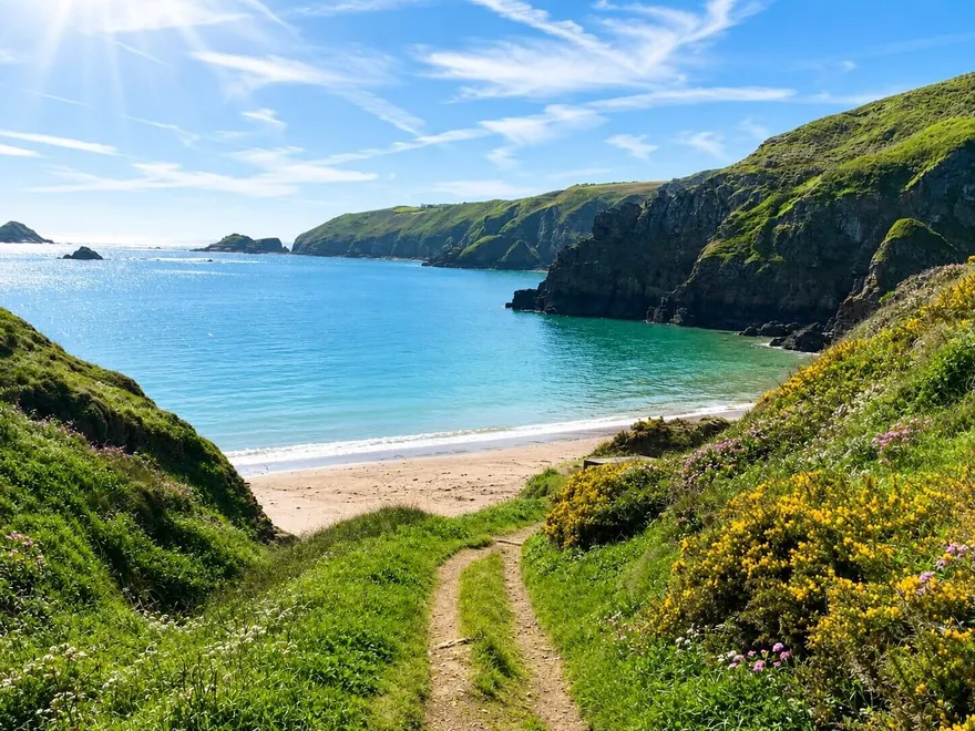 A grassy path down to a turquoise bay on Sark, Channel Islands