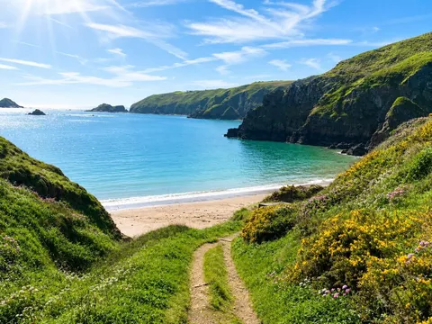 A grassy path descending towards one of Sark's small beaches