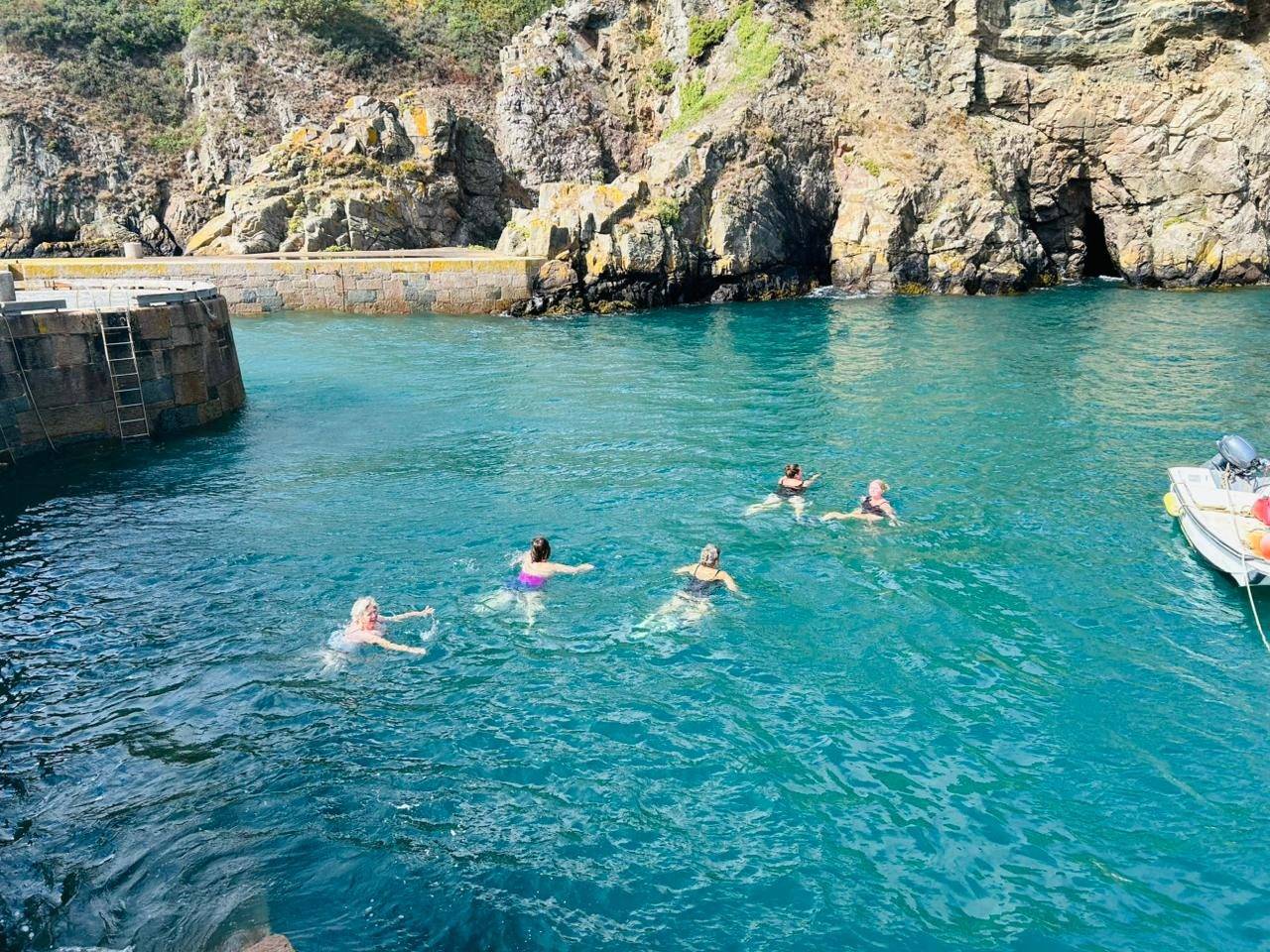 Wild swimming in a sheltered turquoise cove on Sark, Channel Islands